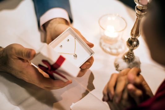 A man gives a woman a heart-shaped necklace and earrings as a Valentine's Day Gift idea.