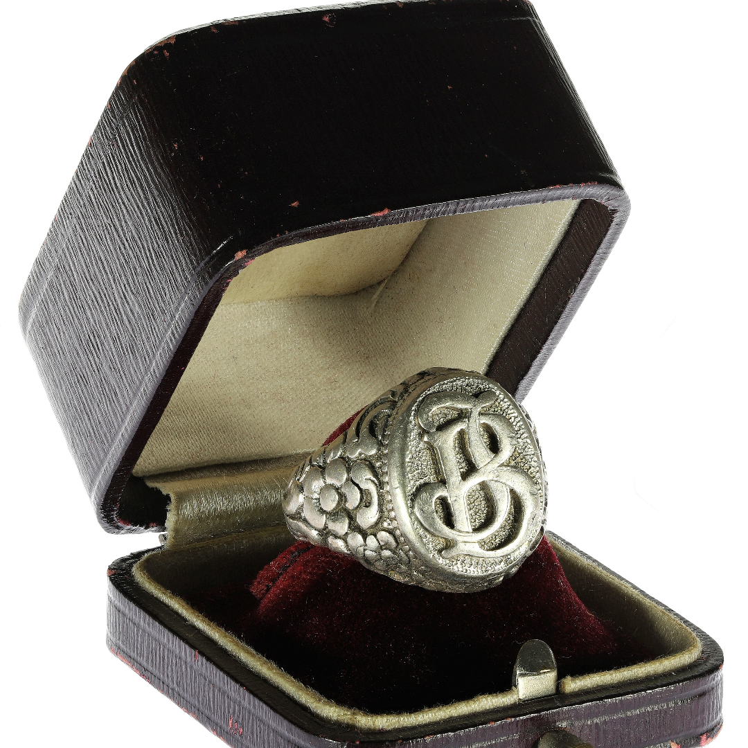 A laser engraving of a person's initials in a men's ring.