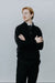 Person wearing a black outfit against a plain background